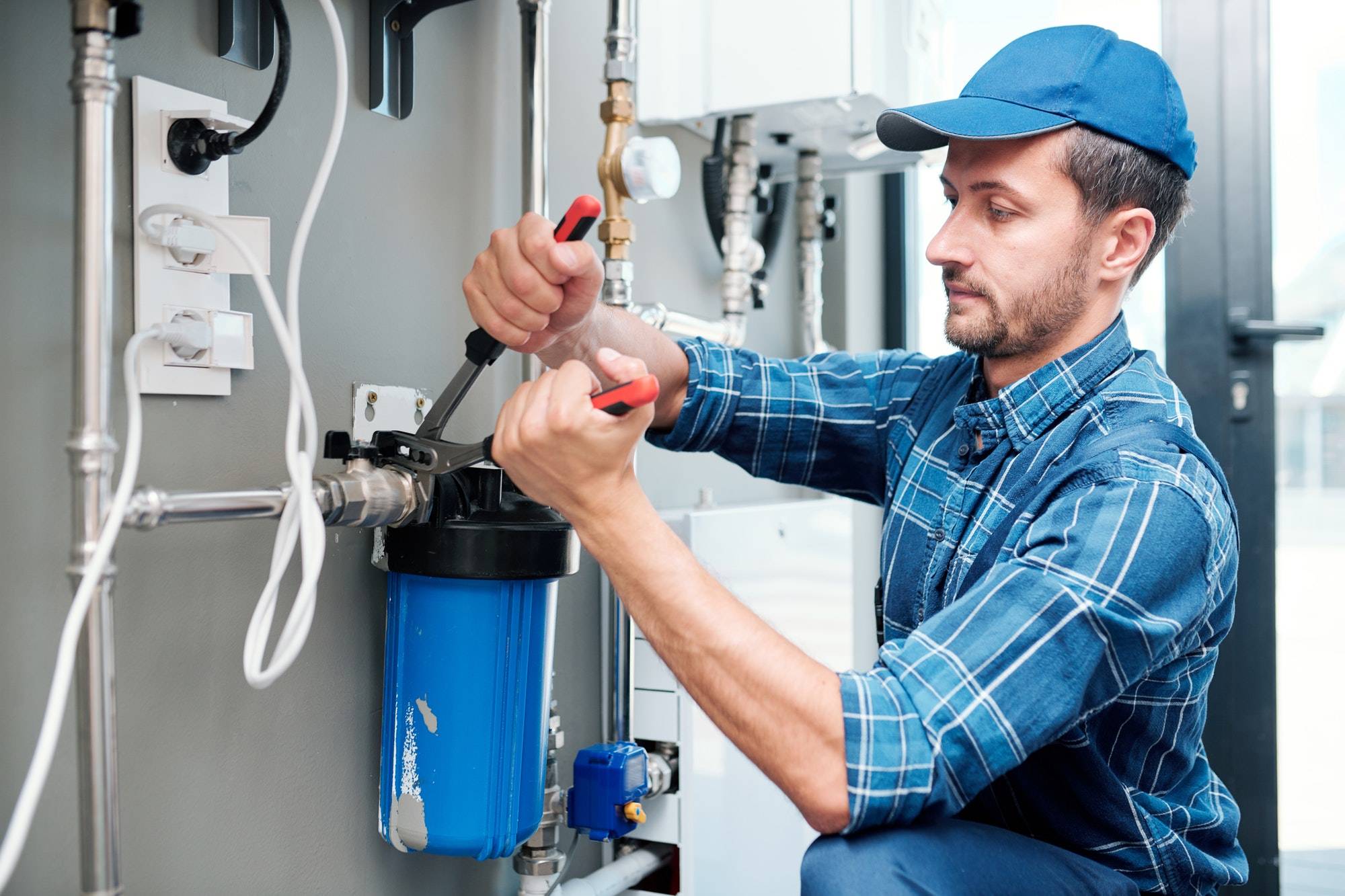 young-plumber-or-technician-installing-or-repairing-system-of-water-filtration.jpg